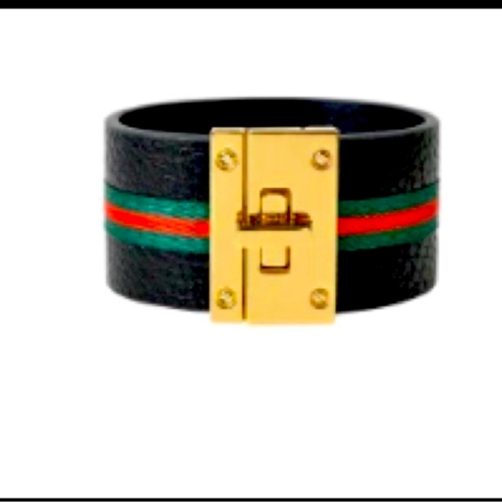 Leather cuff with stripe accent and gold turnlock clasp.